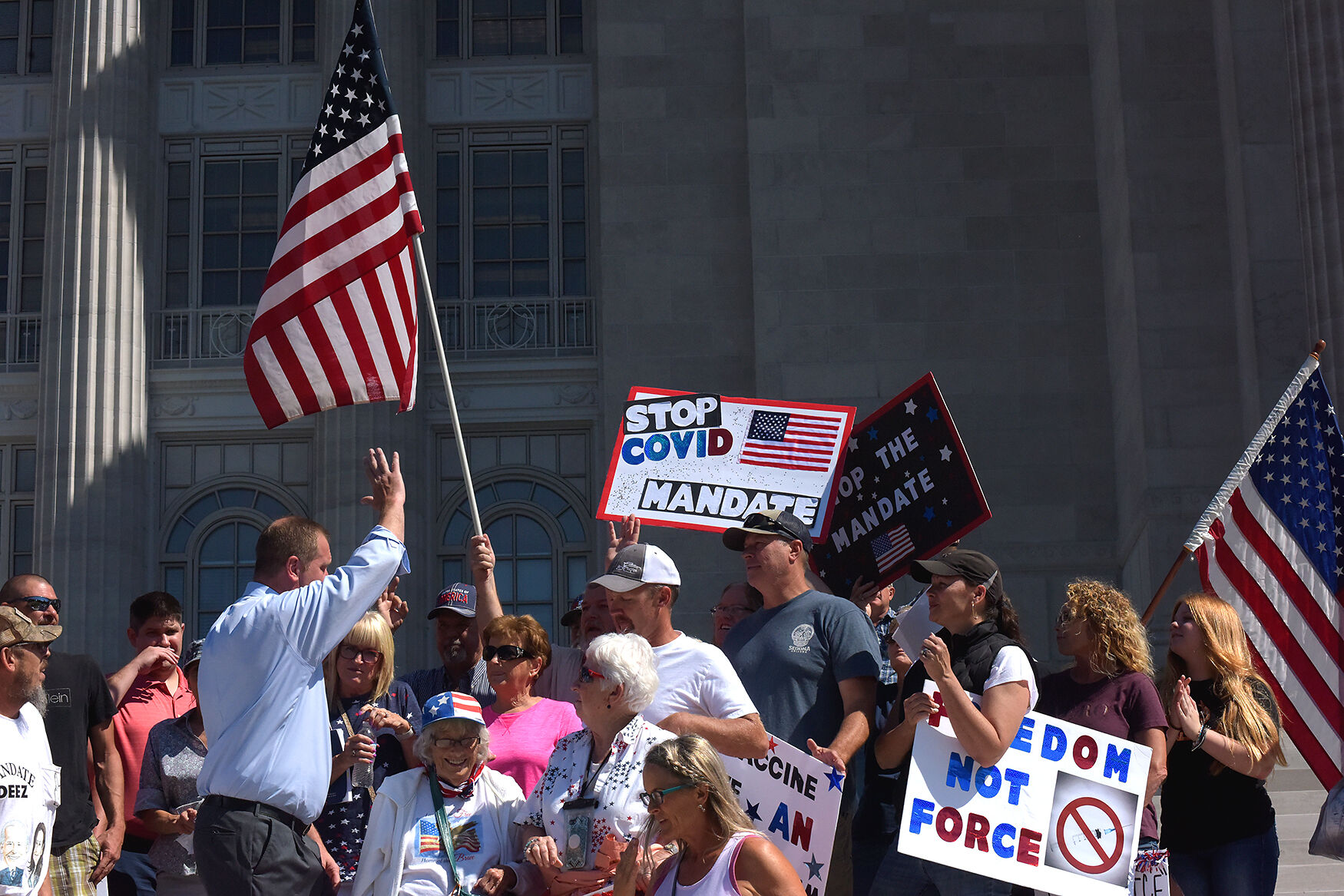 Eric Schmitt waves to a group of protestors
